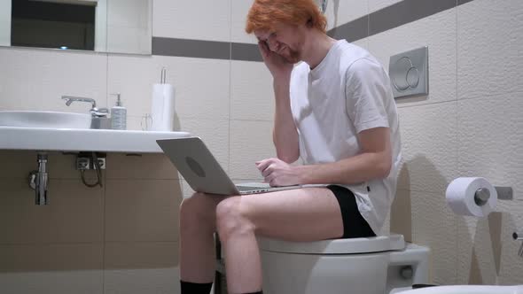 Headache Tired Man Using Laptop in Bathroom Commode