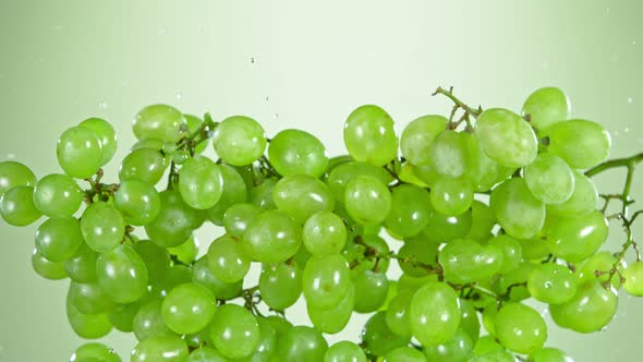 Super Slow Motion Shot of Flying Fresh Green Grapes and Water Side Splash at 1000 Fps