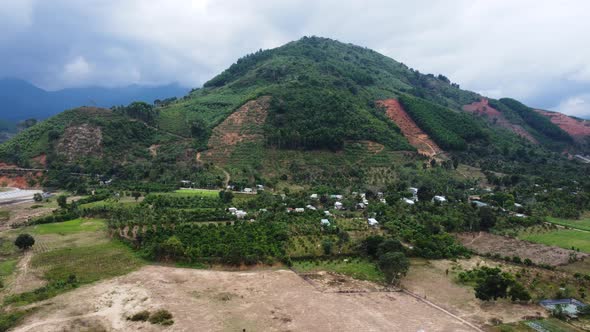 Rural scene, mountain with areas of deforestation, Vietnam. Aerial, pan left