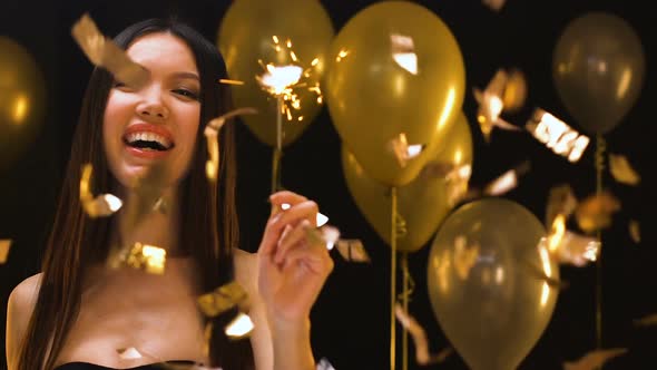 Happy Asian Woman Waving Bengal Light Under Falling Confetti, Party Celebration