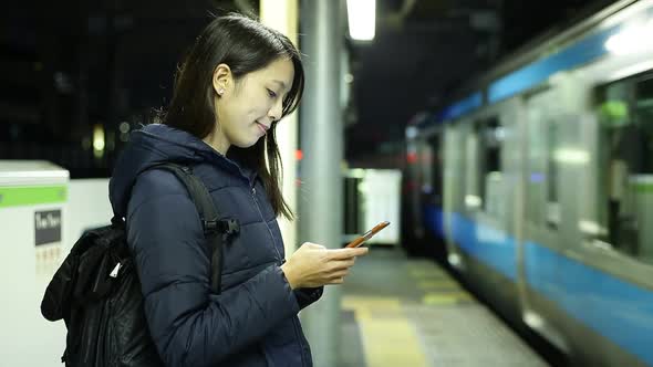 Woman use of the cellphone at train station platform 