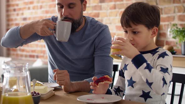 Video of father and son eating breakfast together at the morning. Shot with RED helium camera in 8K.