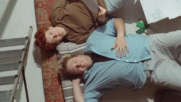 Couple Lying on Floor and Smiling at Camera