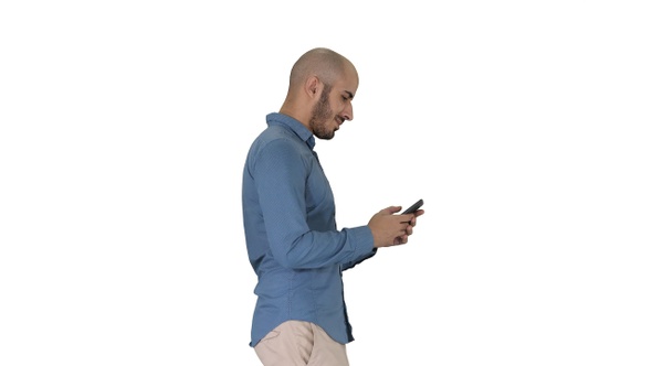 Young man walking and using a phone on white background.