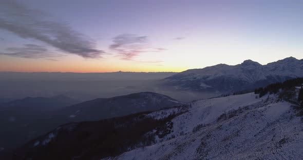 Backward Aerial Top View Over Winter Snowy Mountain with Car Travelling on Road