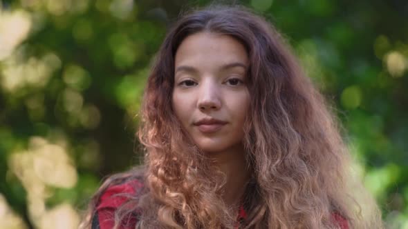 Fashionable Curly Brown Haired Lady Poses for Camera Closeup