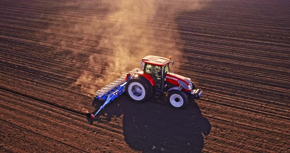 Farmer in tractor seeding corn on agricultural field