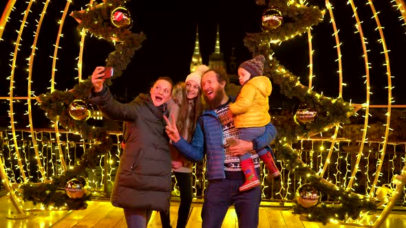 Family posing for photo in front of decoration at Christmas market.