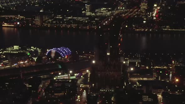 AERIAL: Beautiful Wide Shot Over Cologne Germany at Night Time with City Lights 
