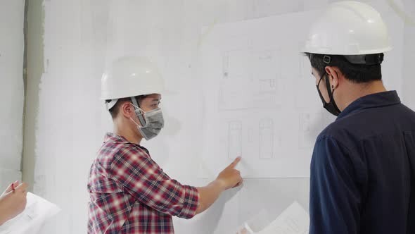 Construction worker team with blueprint meeting and discussing at construction site