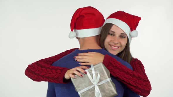 Charming Young Woman in Christmas Hat, Holding Her Present Hugging Her Man 1080p