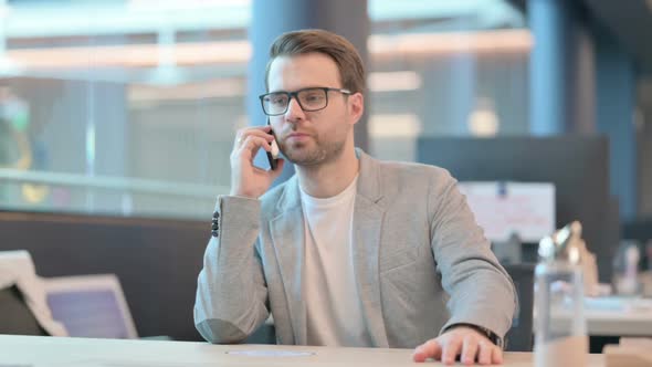 Casual Man Talking on Phone in Office