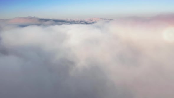 Beautiful Aerial Over the Tops of White Clouds on Sunrise. Background Copy Space