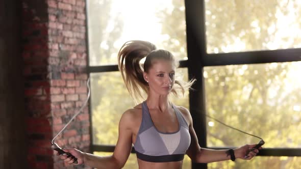 Cropped Close Up Footage of Fitness Woman with Ponytail Jumping on Skipping Rope in Gym