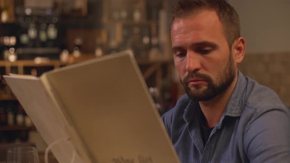 Confident Bearded Caucasian Middleaged Male with Beard Studying Menu at Restaurant in Slowmotion
