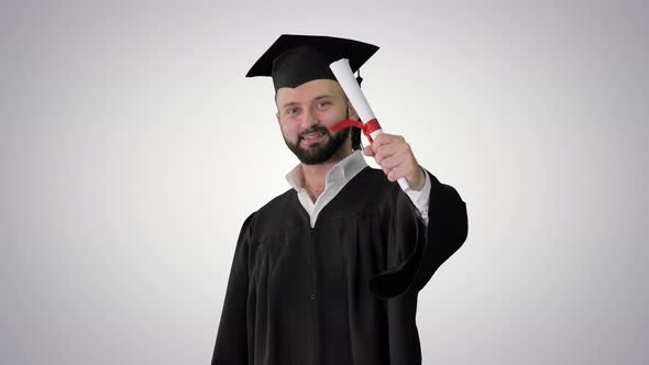 Young Male Smiling Graduate Showing Thumb Up on Gradient Background.