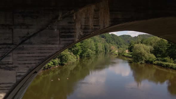 Rusty, old train trestle leading over the Sieg river in west Germany on a sunny spring day. Aerial f