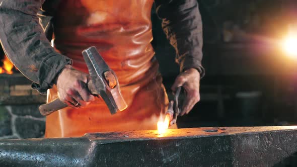 Slow Motion of Burning Iron Being Hammered