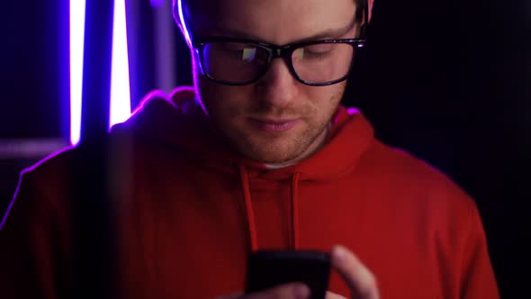Young Man in Glasses with Smartphone in Dark Room 31