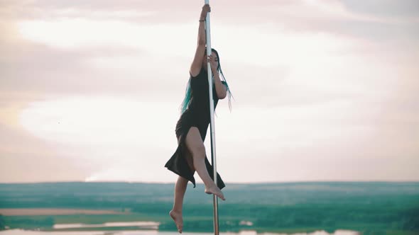 Woman with Blue Braids Dancing By the Pole - Shows Tricks