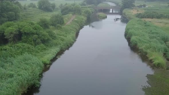 Panning from left to right above the river Otter in Devon England. The river is surrounded by fields