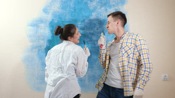 Joyful Guy and Lady Pretend to Sing Into Paintbrushes As Mic