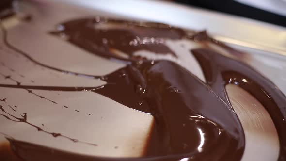 Confectioner is Working with Melted Chocolate Using Putty Knife