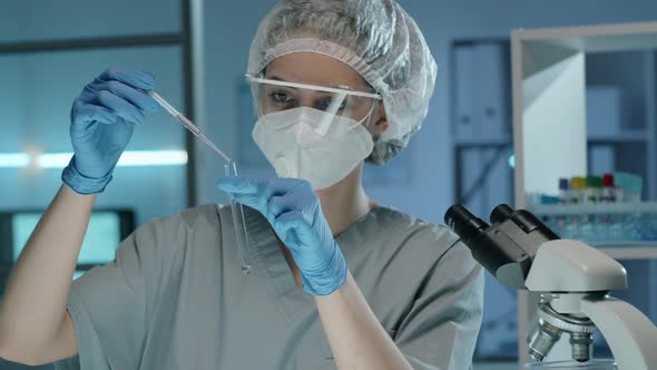 Female Lab Scientist in Mask Doing Chemical Experiment