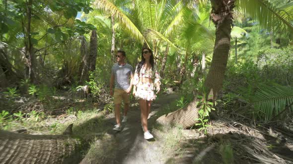 A man and woman couple walking on a path in the tropical islands in French Polynesia