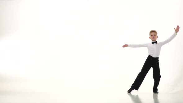 Little Boy the Dancer Spins Out Gracefully the Movements. White Background. Slow Monion