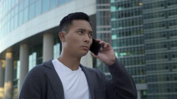 Real Time Shot of a Young Asian Guy Talking on the Phone in Moscow. Moscow Is the Capital and the