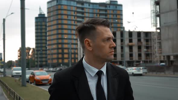 Businessman in Suit Walking Near Newly Constructed Building