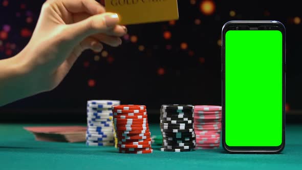 Woman Showing Gold Card on Background of Casino Chips and Green Screen Phone