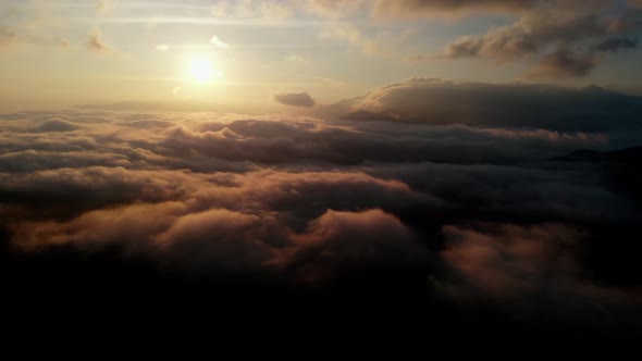 Aerial View Flying Over Clouds on Sun Rise in Mountains