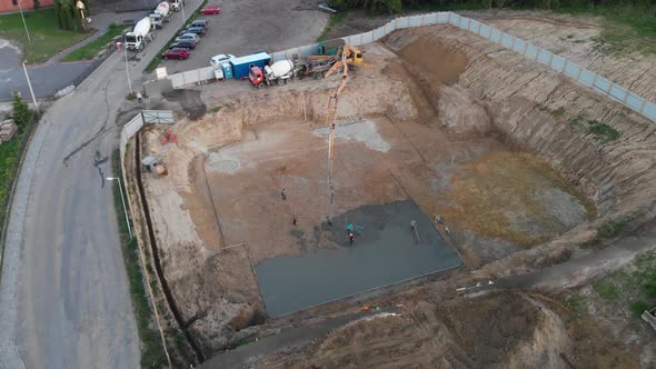 Aerial view construction workers pouring concrete at construction site basis.