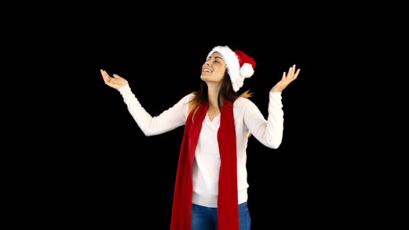 Woman in santa hat and warm clothing looking upwards