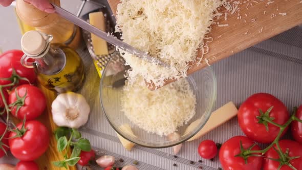 Making Pasta Carbonara  Pouring Grated Parmesan Cheese Into Glass Bowl