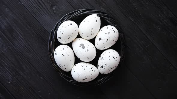 Whole Chicken Eggs in a Nest on a Black Rustic Wooden Background. Easter Symbols