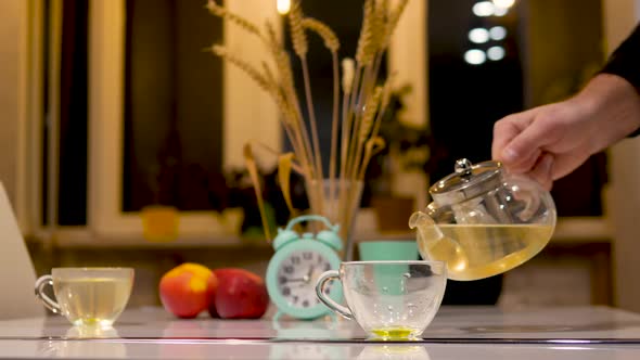 Brewed Tea In A Teapot And A Cup. Natural Herbal Drink. Pour Hot Tea Into A Transparent Tea Cup.