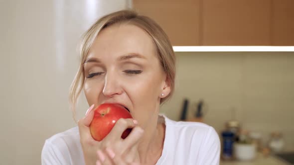 The Girl is Biting a Red Apple