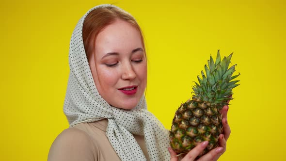 Charming Redhead Woman with Green Eyes Holding Pineapple Looking at Camera Smiling