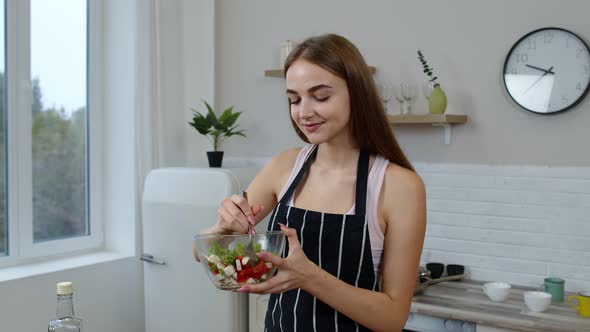 Happy Young Woman Eating Fresh Raw Vegetable Salad Posing at Kitchen Having Positive Emotion