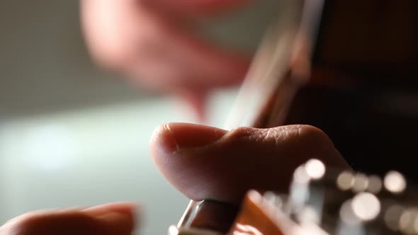 Male guitarist plucking the strings of a spanish guitar. Skilled male artist. Macro shot, close up.
