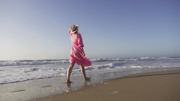 Silhouette Woman in Flying in Wind Pink Dress at Sunset Raising Head Up in Air