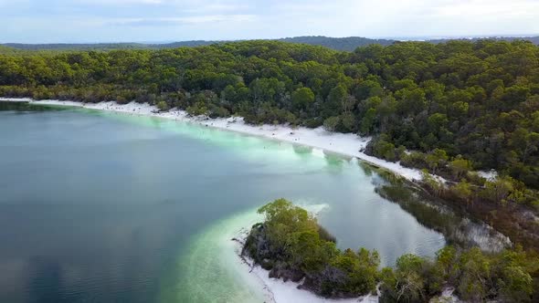 Drone footage slowly flying up and away from the main swimming beach at Lake McKenzie, Fraser Island