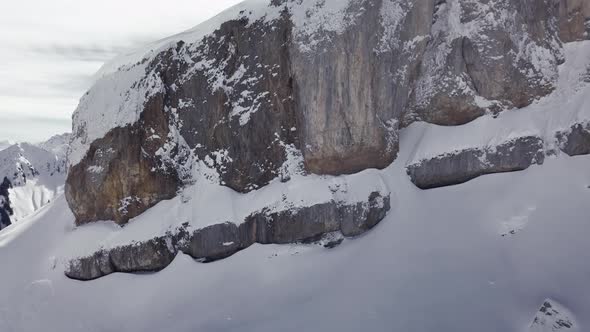 Aerial drone shot on montain rock in the alps, Austria, Kleinwalsertal, skiing area, snowy mountains