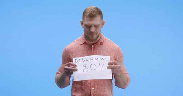 Young Man Holding Discount Sign