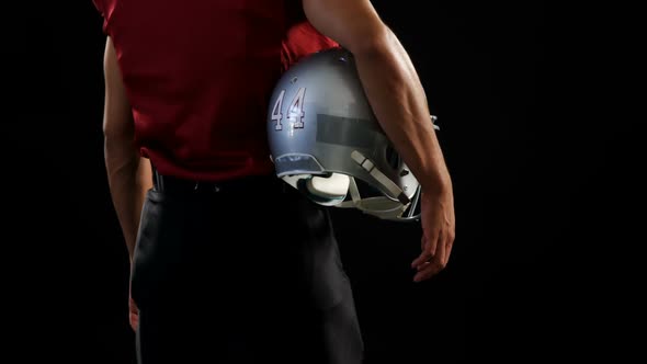 American football player holding a ball and head gear 4k