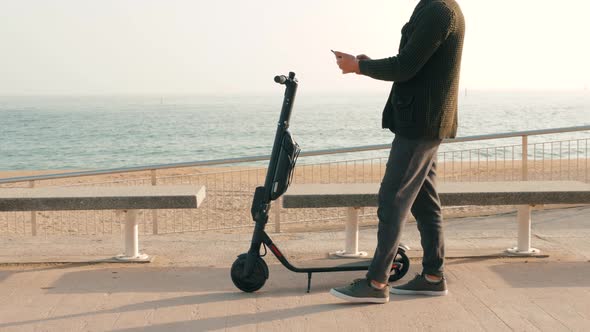 Tourist Man Take Electric Kick Scooter or Bike Bicycle in Sharing Parking Lot Tourist Phone