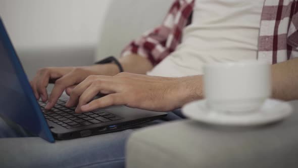 Close-up of Male Hands Typing on Laptop Keyboard